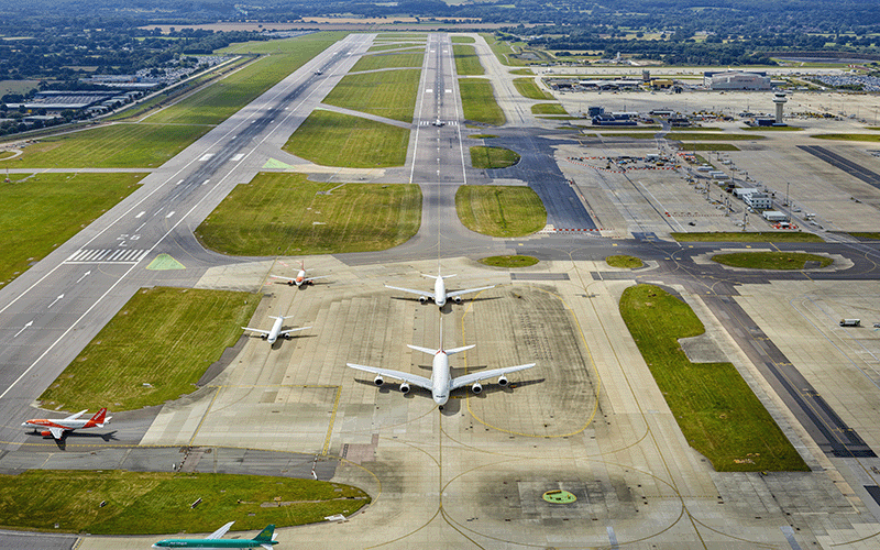 Low angle Aerial photograph of London Gatwick's main and northern runway and taxiway with planes taxiing